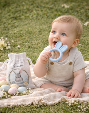 My First Easter bunny teether personalised baby gift set with baby sitting on picnic blanket outdoors