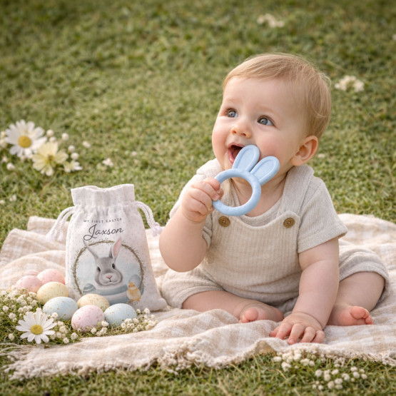 My First Easter bunny teether personalised baby gift set with baby sitting on picnic blanket outdoors