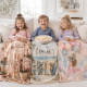 Three children cuddled under personalised fleece blankets in a cosy neutral living room
