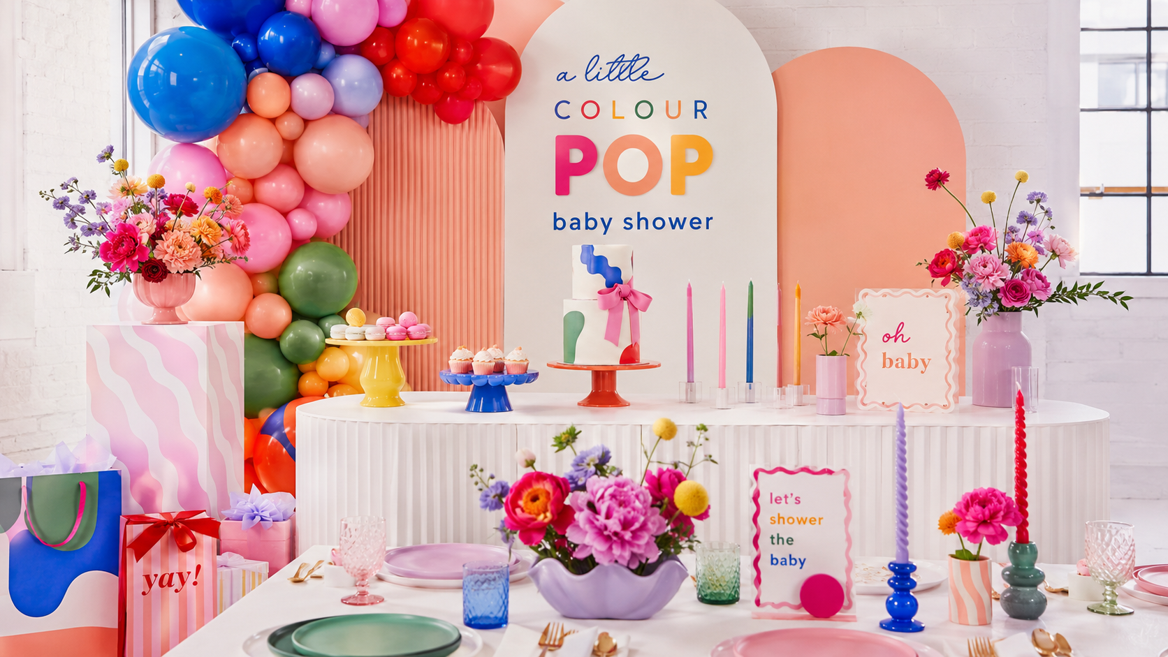 Modern colourful baby shower with bold balloons, bright cake and personalised baby gifts